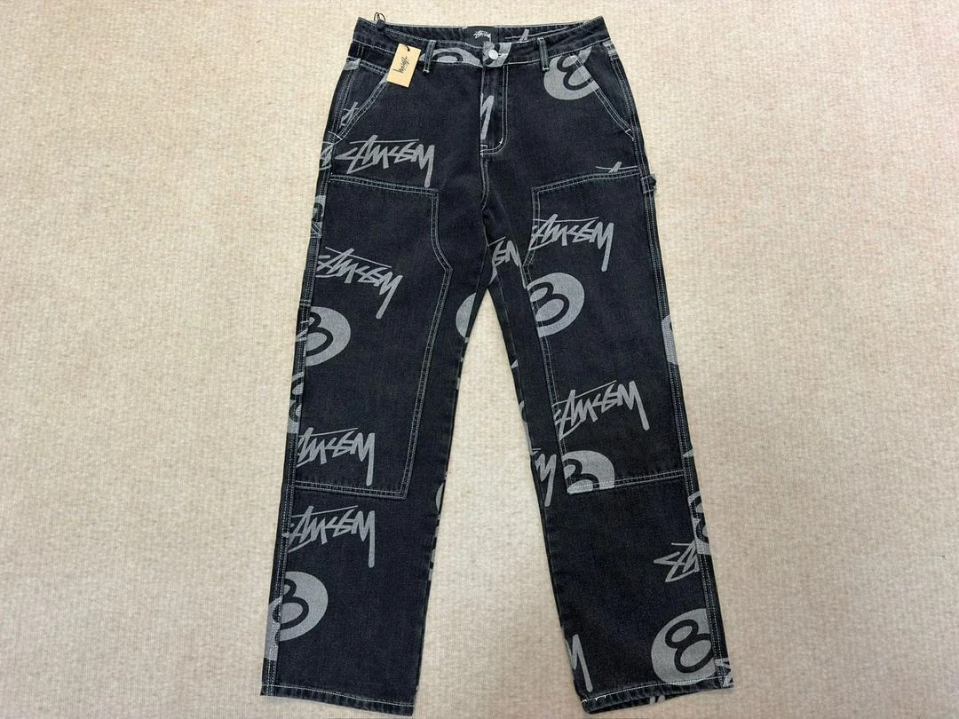 Mörka jeans med ljusa Stüssy-bokstäver
