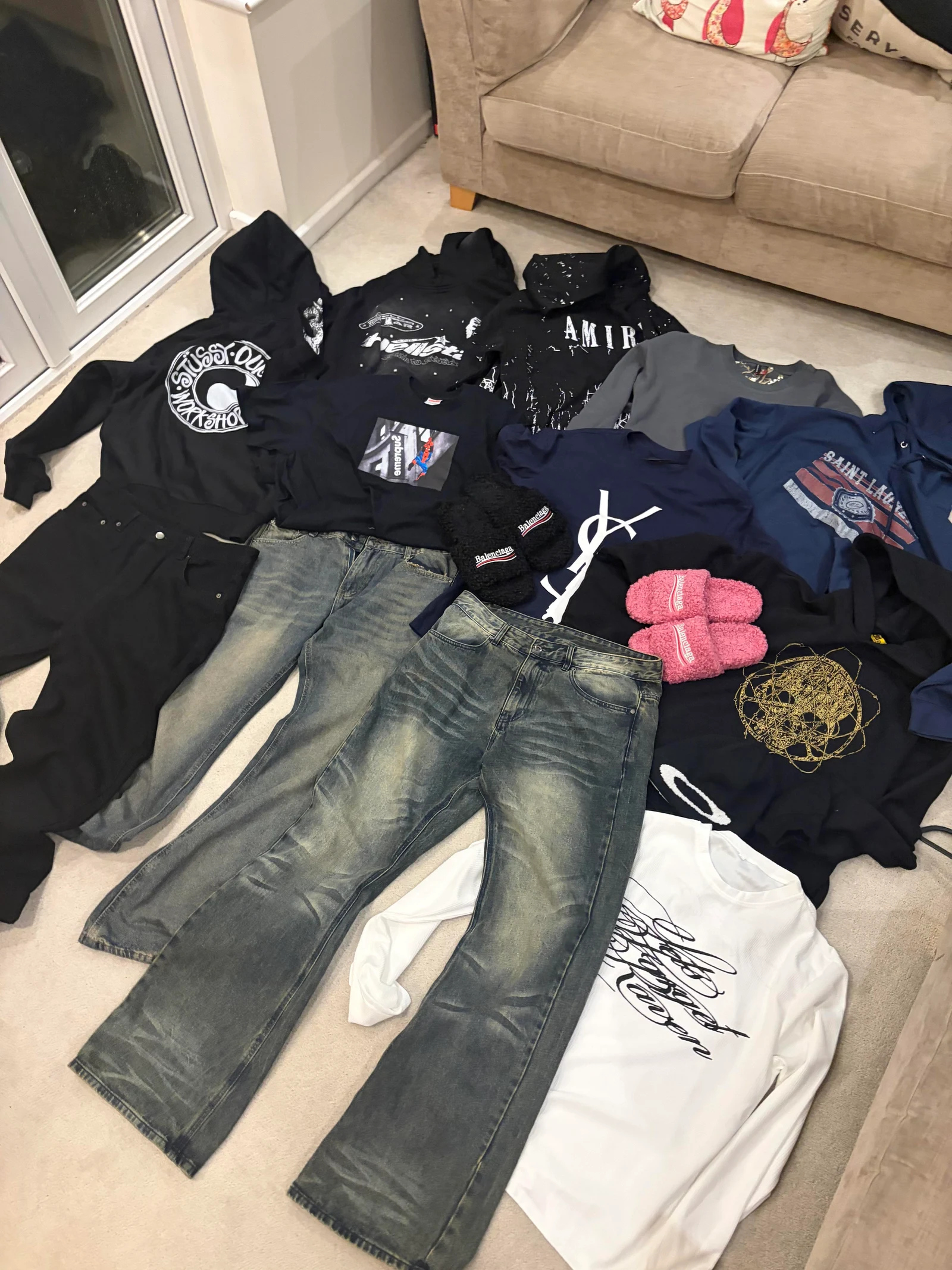 Overview of the UK haul with hoodies, jeans, tops, slides and a beanie